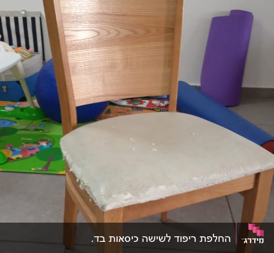 כיסא עץ עם ריפוד קרוע על המושב